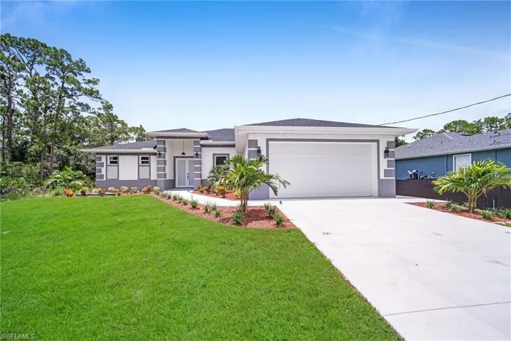 View of front of home featuring a garage and a front lawn
