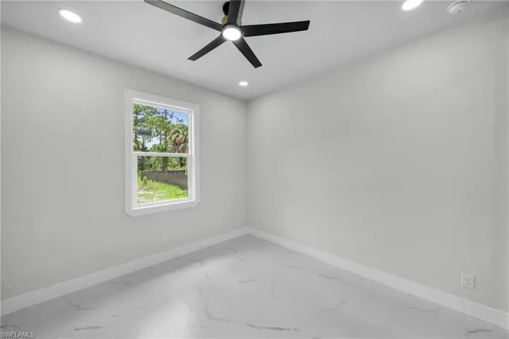 Unfurnished room with tile patterned floors and ceiling fan