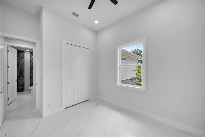 Unfurnished bedroom with ceiling fan, light tile patterned floors, and a closet