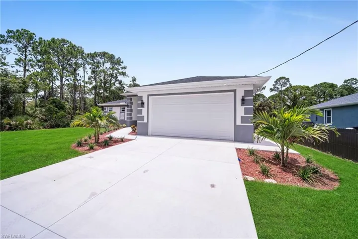 View of front of home with a garage and a front lawn
