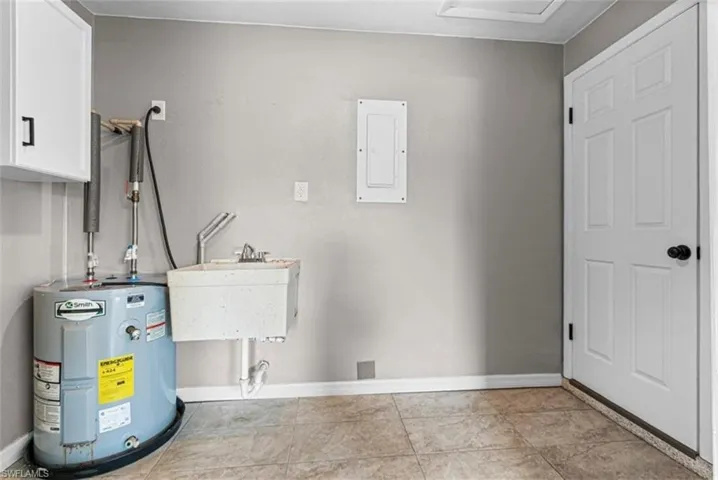 Utility Room with electric water heater, and sink