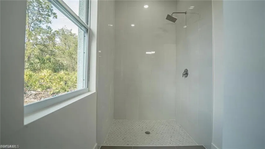 Full bath featuring plenty of natural light and tiled shower