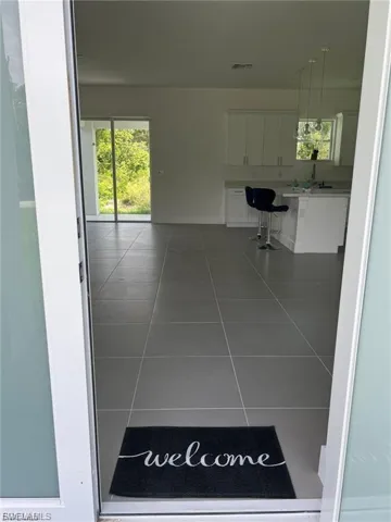 Corridor featuring tile patterned flooring and baseboards