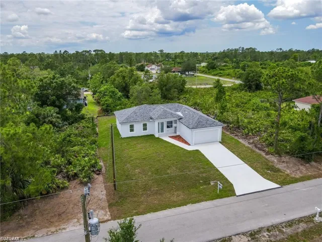 Aerial view of property and surrounding area with a heavily wooded area