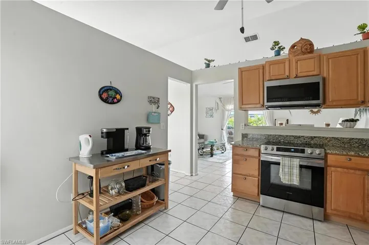 Kitchen featuring light wood-finish cabinetry, stainless steel appliances, and a tiled backsplash