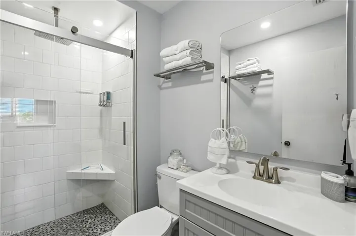 Bathroom featuring a walk-in shower with clear glass enclosure and a rain shower head