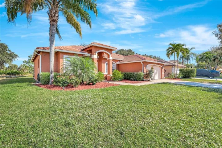 Mediterranean / spanish home featuring stucco siding, a garage, driveway, and a front lawn