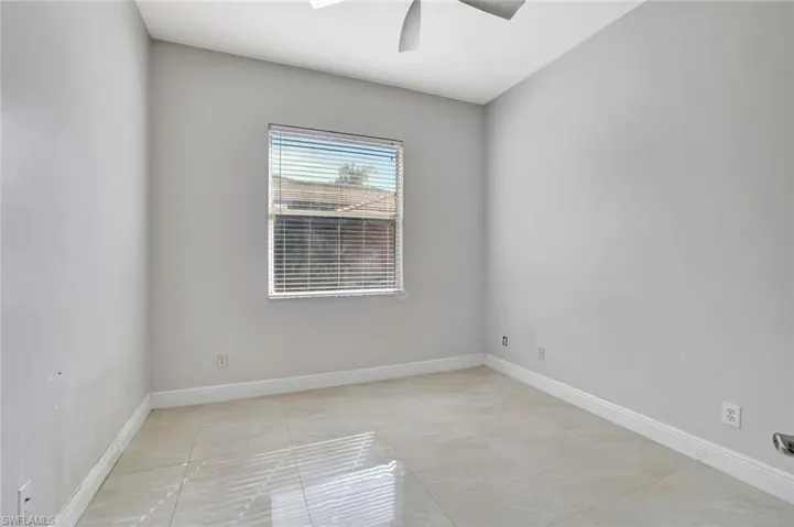 Empty room featuring baseboards and a ceiling fan