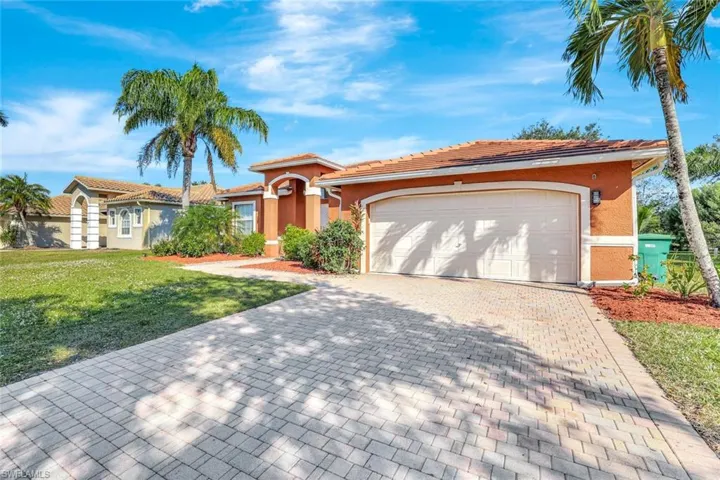 Mediterranean / spanish house featuring stucco siding, decorative driveway, a front yard, and a garage