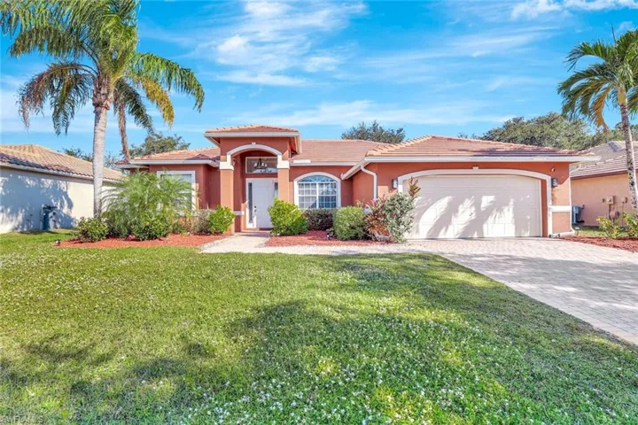 Mediterranean / spanish house featuring stucco siding, a tiled roof, decorative driveway, and a front yard