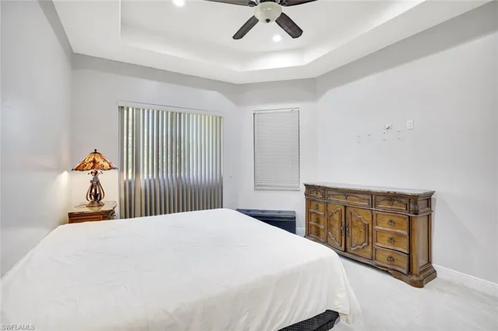 Bedroom featuring a tray ceiling, a ceiling fan, and recessed lighting