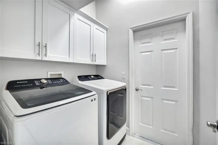 Laundry room featuring washing machine and clothes dryer and cabinet space