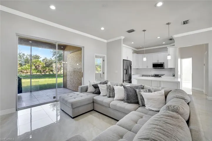 Living area with recessed lighting and ornamental molding
