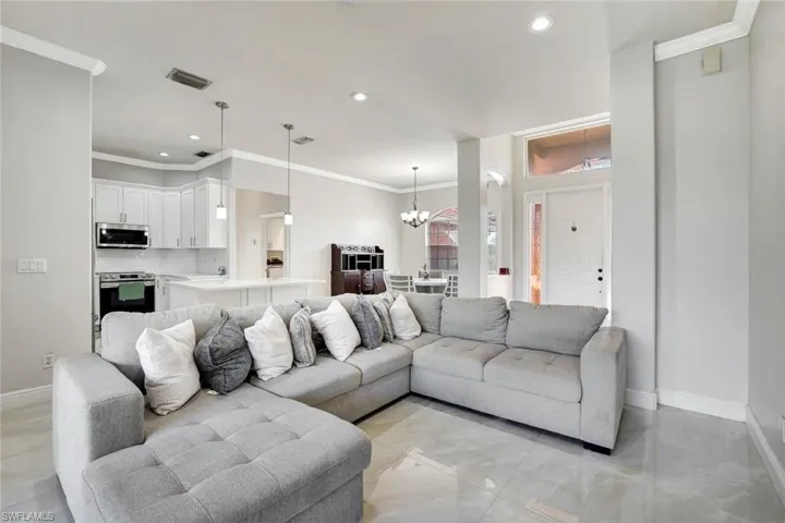 Living area featuring crown molding, a chandelier, and recessed lighting