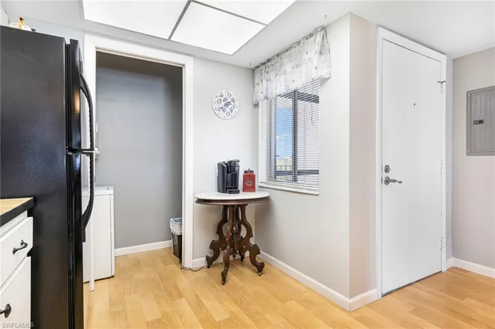 Kitchen featuring black refrigerator, white cabinets, and light hardwood / wood-style floors