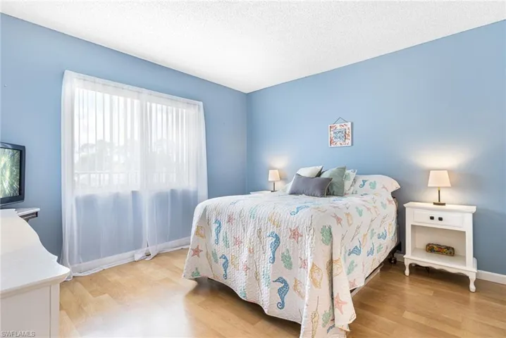 Bedroom with a textured ceiling and light wood-type flooring