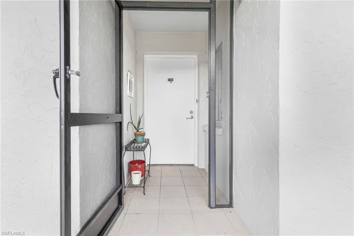 Hallway featuring light tile floors