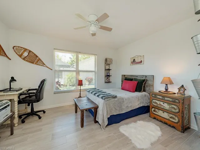Bedroom featuring baseboards, ceiling fan, and light wood-style flooring