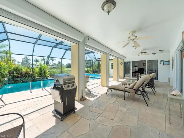 View of patio with a grill, ceiling fan, a lanai, and an outdoor pool