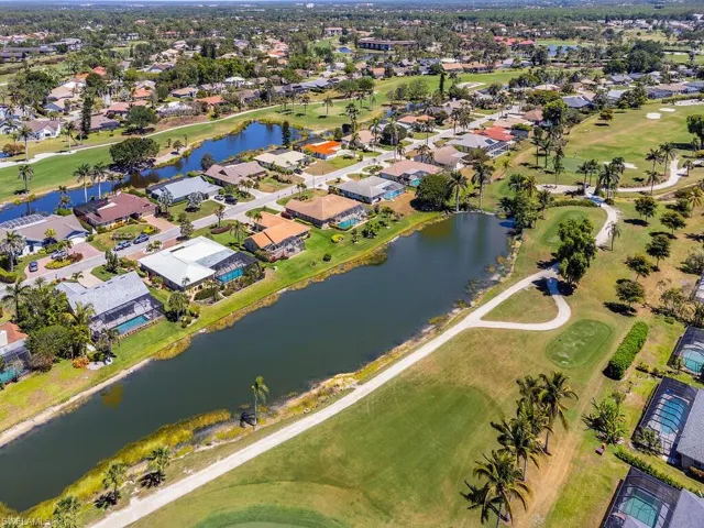 Drone / aerial view with a residential view, golf course view, and a water view