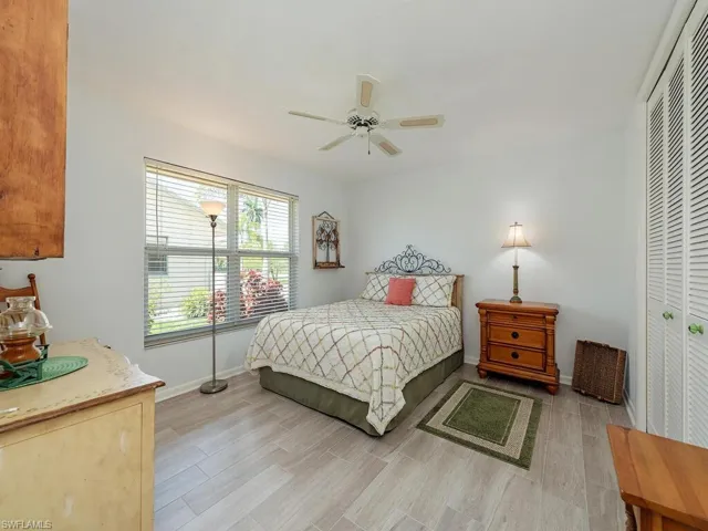 Bedroom with a closet, baseboards, light wood-style flooring, and a ceiling fan