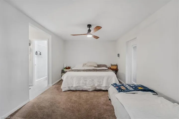 Carpeted bedroom featuring ceiling fan