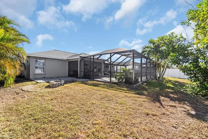 View of yard featuring a fire pit and glass enclosure