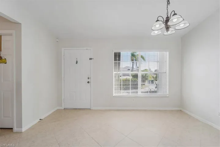 Entryway featuring light tile patterned floors and a chandelier