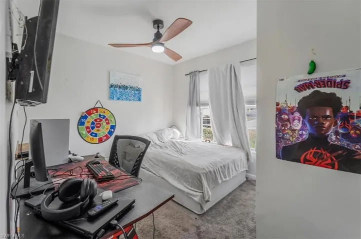 Carpeted 1 st  bedroom featuring ceiling fan