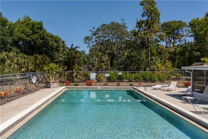 Pool with a patio area and fence