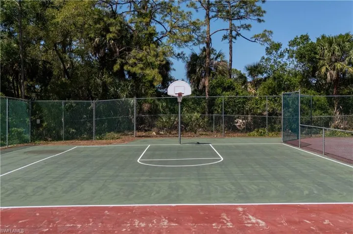 View of basketball court with fence and community basketball court