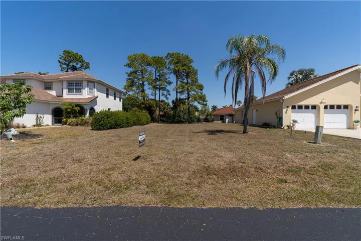 View of yard with an attached garage and concrete driveway