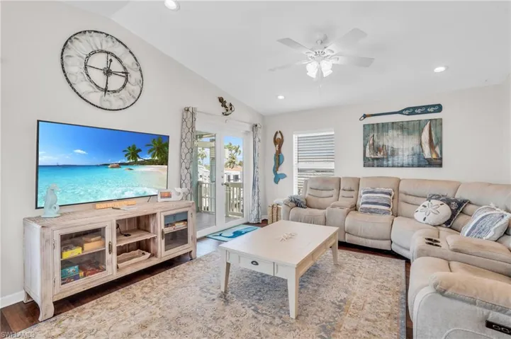 Living room with french doors, wood-type flooring, ceiling fan, and vaulted ceiling