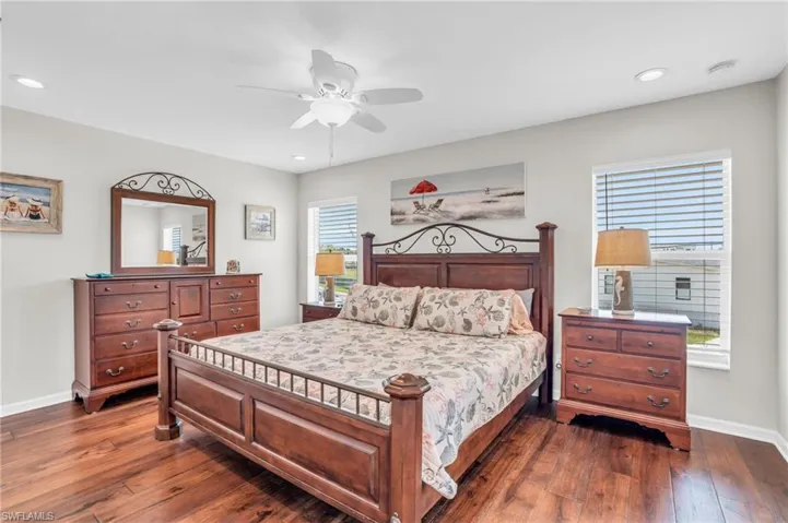 Bedroom with ceiling fan and dark wood-type flooring