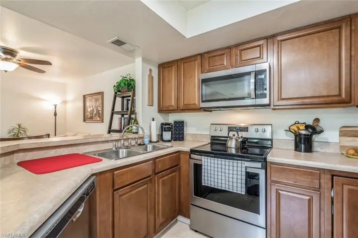 Kitchen featuring ceiling fan, stainless steel appliances, and sink