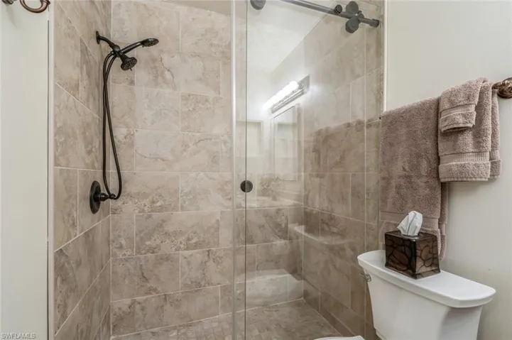 Bathroom featuring an enclosed shower and toilet