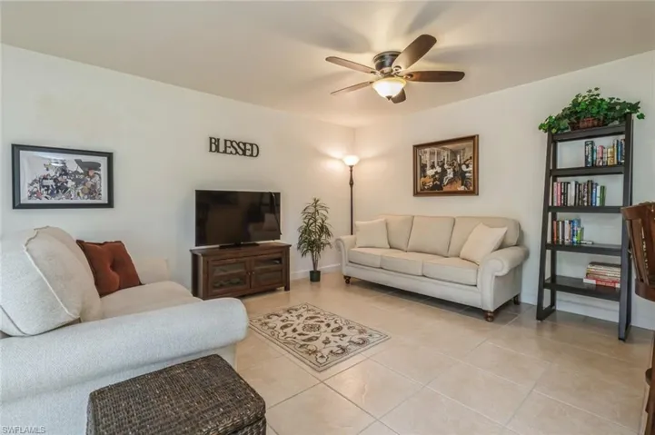 Living room featuring ceiling fan and light tile flooring