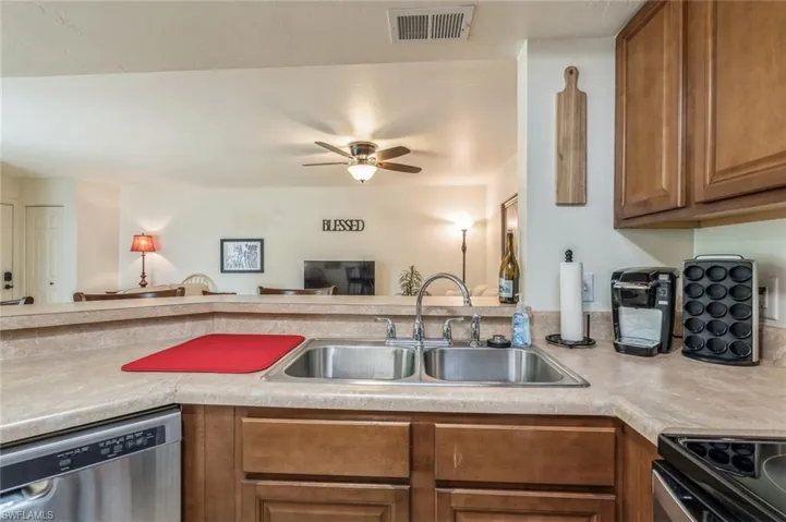 Kitchen with ceiling fan, sink, range, and stainless steel dishwasher