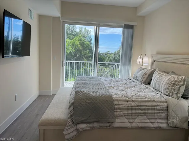 Bedroom with hardwood / wood-style floors and access to outside