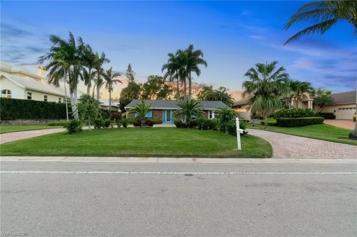 View of front exsisting elevation with a front lawn and decorative driveway