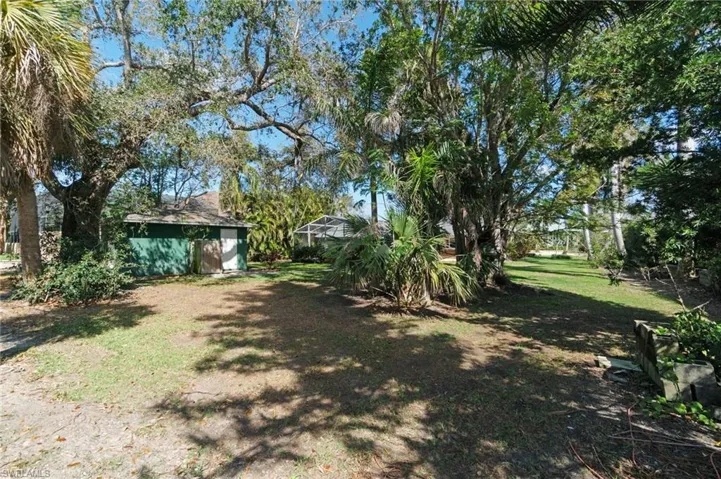 View of rear yard featuring a lanai and an outdoor storage/garage structure.