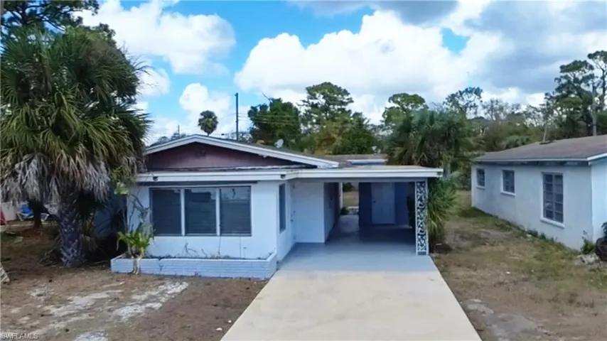 View of front of home featuring a carport, concrete driveway, a patio area, and stucco siding