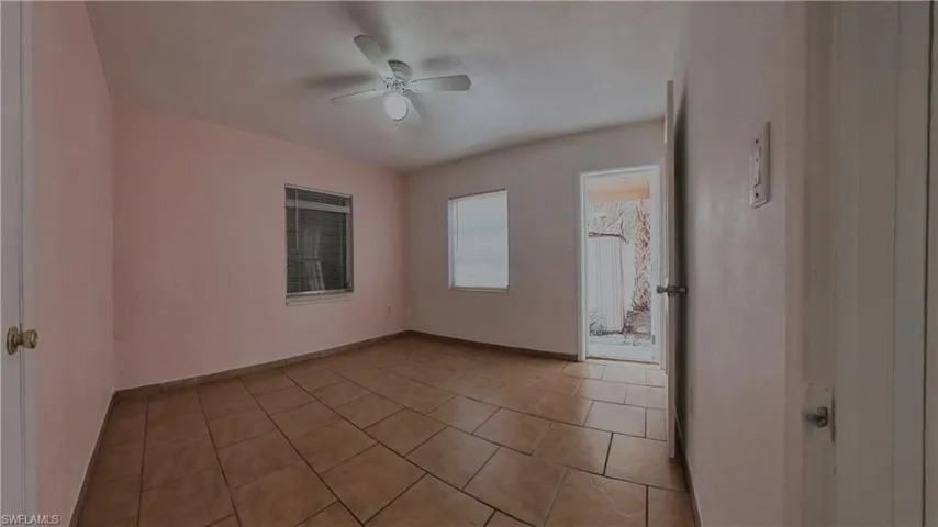 Empty room featuring a ceiling fan and light tile patterned flooring