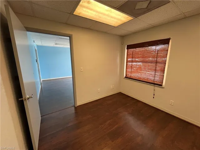 Interior space featuring wood-finish flooring, a window with woven blinds, and recessed lighting