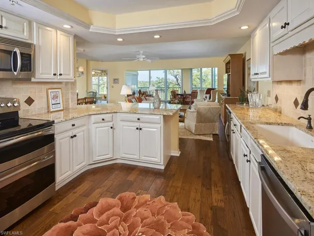 Lovely white washed cabinetry with stainless steel appliances and tray ceiling