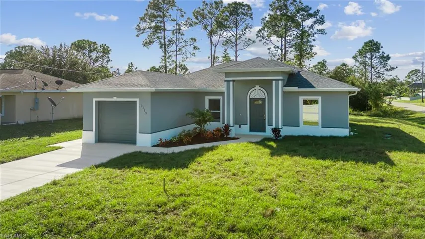 Single story home with a front yard and a garage