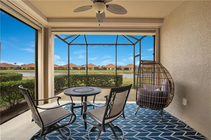 Sunroom / solarium featuring a water view, a residential view, and a ceiling fan