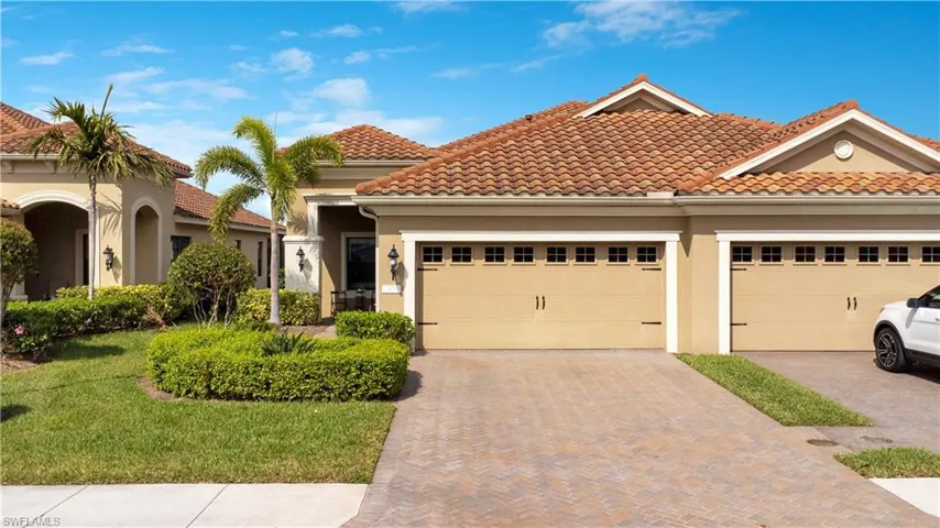 Mediterranean / spanish-style home featuring a garage, a tiled roof, decorative driveway, stucco siding, and a front lawn