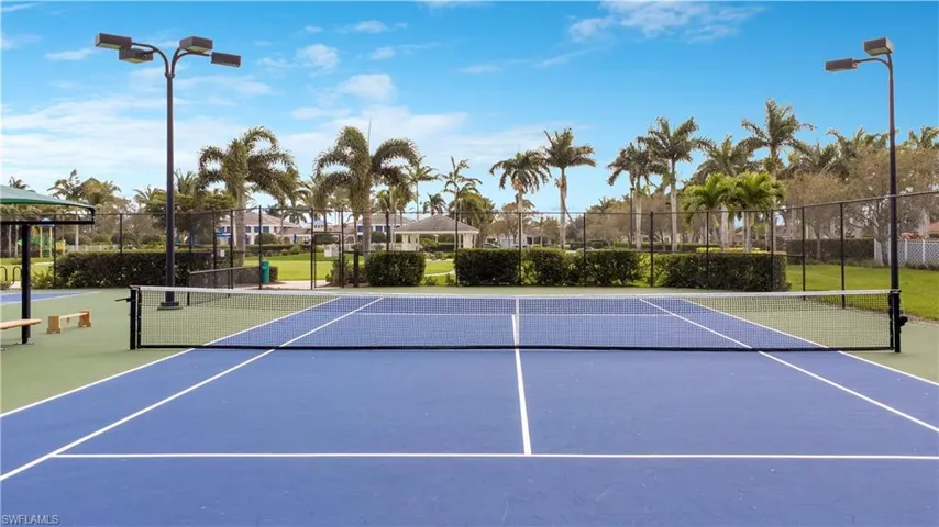 View of tennis court with community basketball court and fence