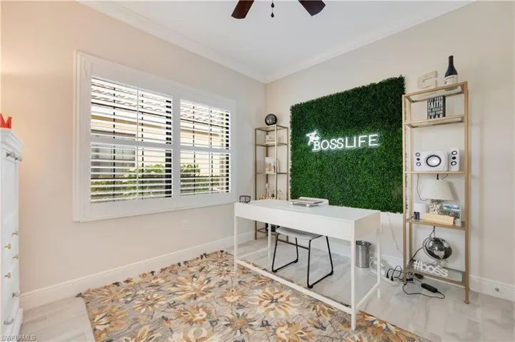 Office space with a ceiling fan, baseboards, and crown molding